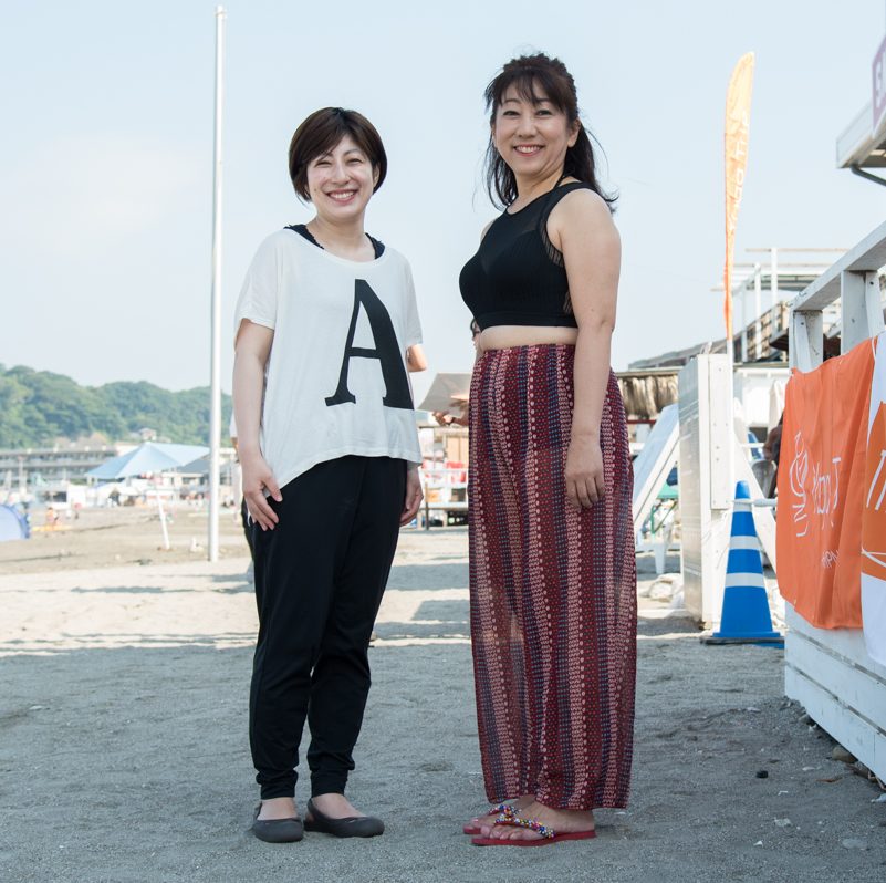 ビーチで立つ田邉晃子さんと山口優香子さんの全身