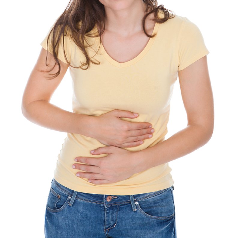 お腹が減ってお腹を押さえる女性