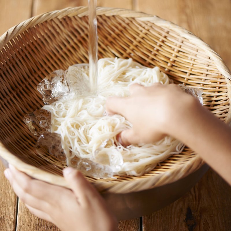 流水でそうめんを洗う