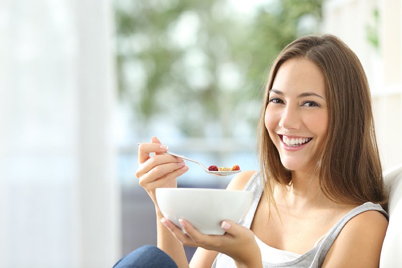 ヨーグとをスプーンで食べる女性