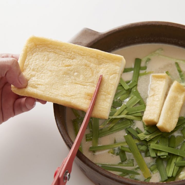 豚バラ肉のごまラー油鍋作り方の手順。はんぺんをハサミで切って鍋に入れる