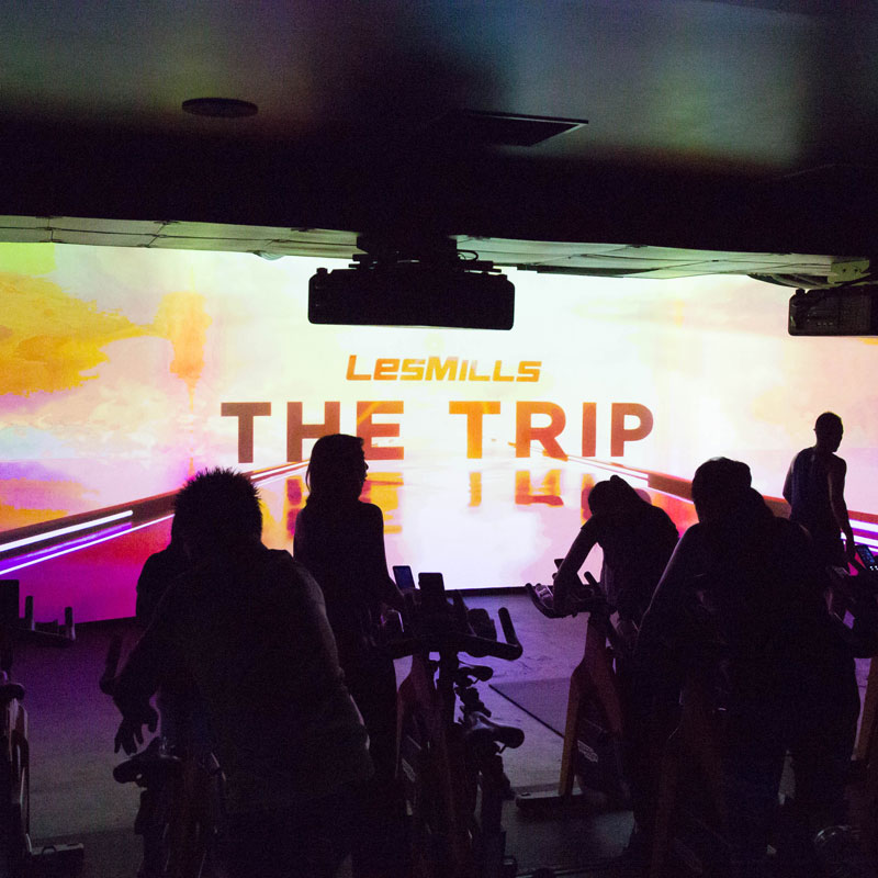 「CYCLE & STUDIO R」VRサイクル『THE TRIP』の画面と体験者の後ろ姿