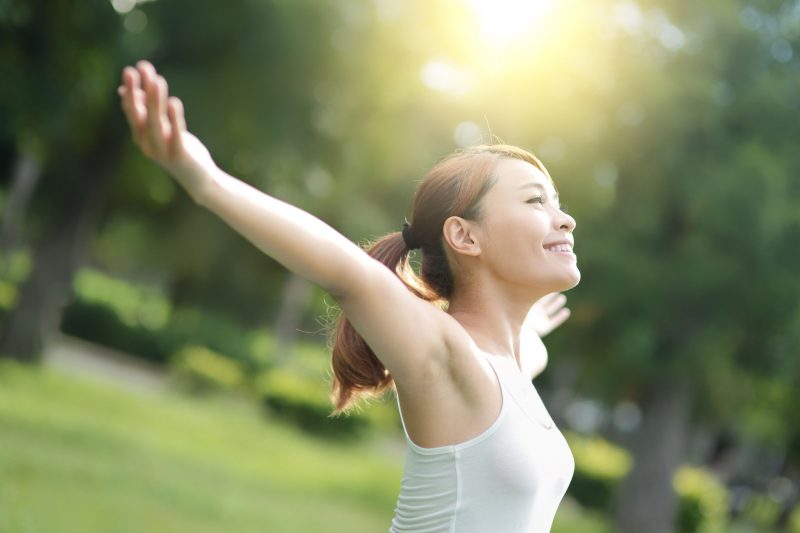 気持ちよく伸びをする健康的な女性の姿