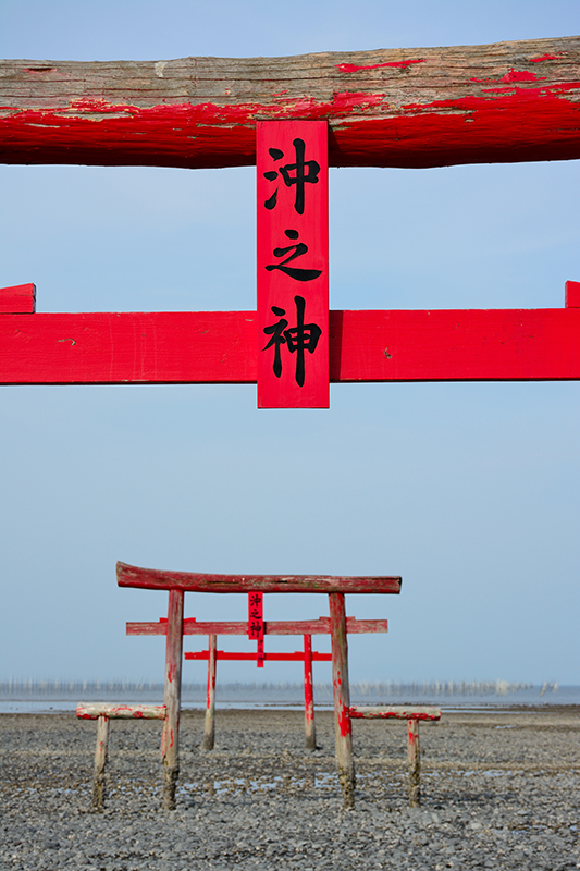 干潟に朱色の鳥居がいくつも建っている。ところどころ色が落ちたり、風化していたりする