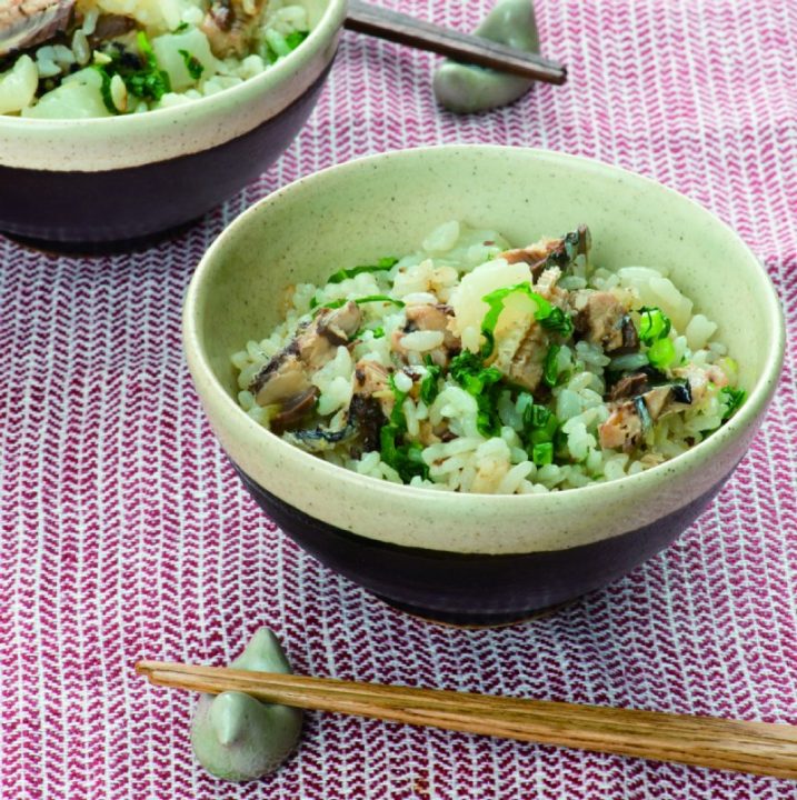 いわしと大根の炊き込みご飯が茶碗に入ってお箸と箸置きとともに食卓にならんでいる