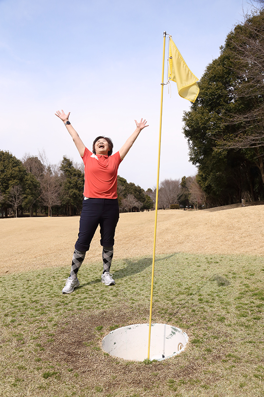 オバ記者が大きなピンの前で手を上げている