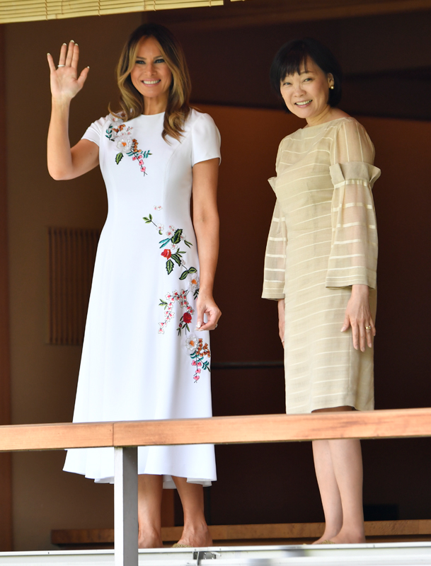 メラニア夫人は手を振り、安倍昭恵夫人は笑顔で会釈している