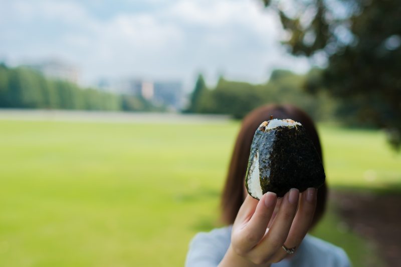 おにぎりを手にする女性