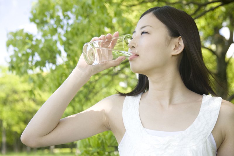 コップの水を飲む女性