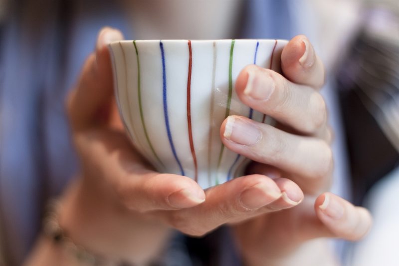 湯飲みを手にしている