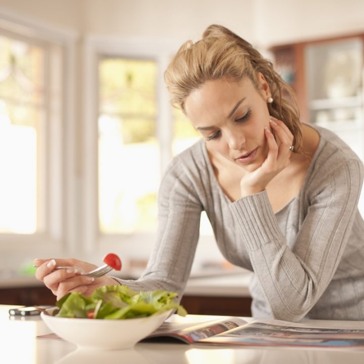 サラダを食べながら本を読む女性