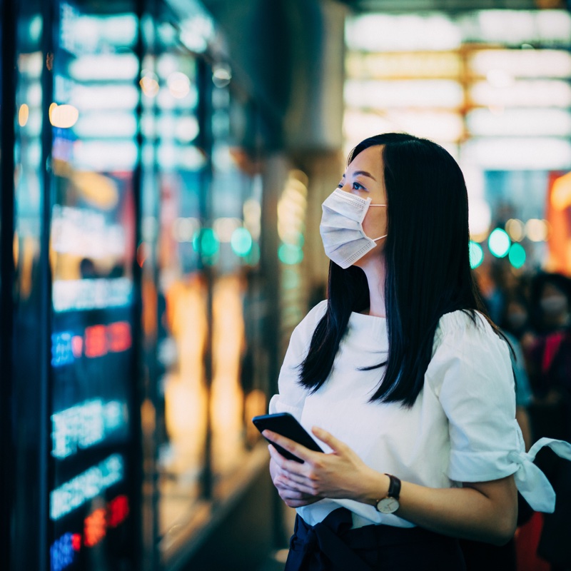 夜の街でマスクをしている女性