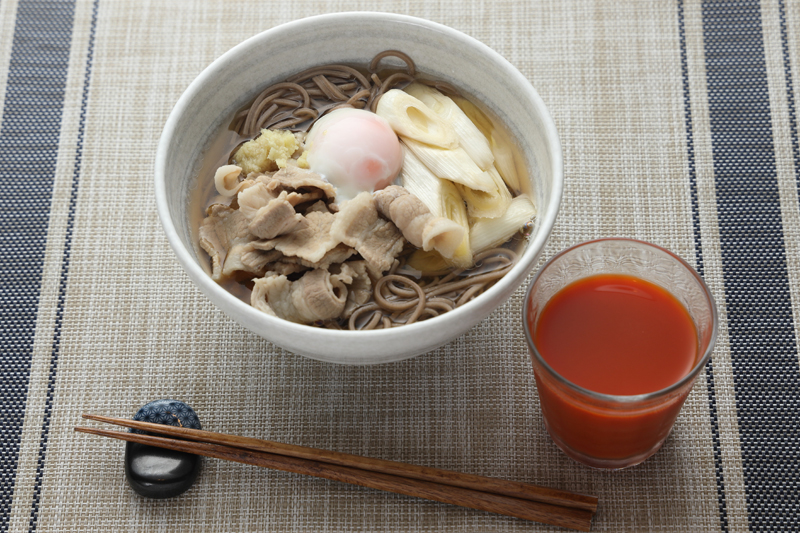 豚南蛮そばの温泉卵のせと野菜ジュースが並んでいる