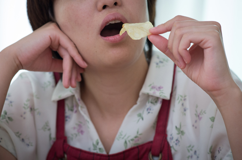 ポテトチップスを食べる女性