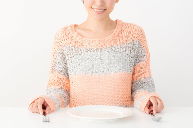 空の皿を前に断食を決意する女性
