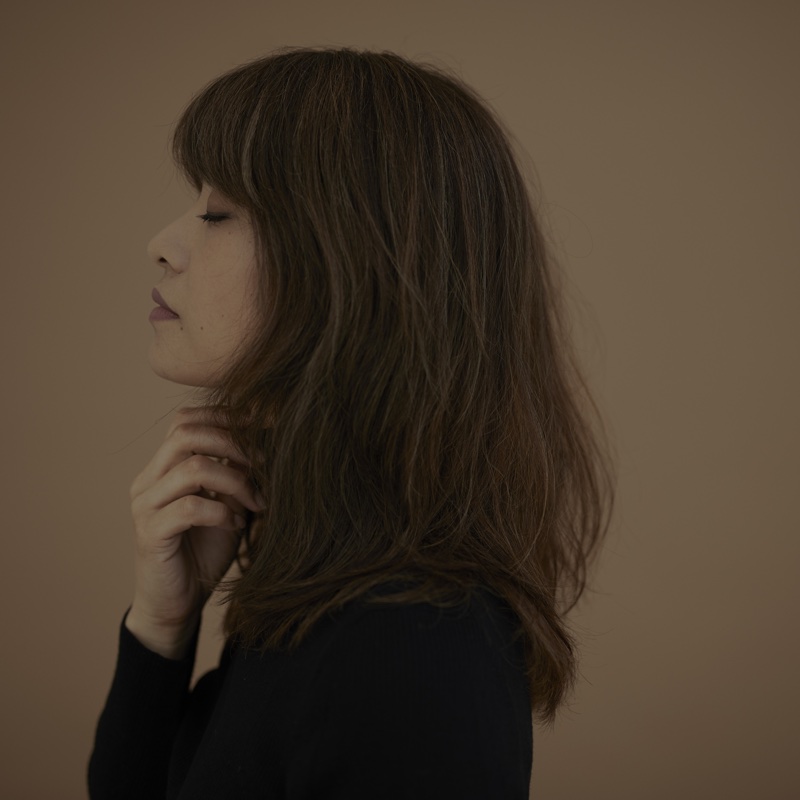 のどを押さえる横顔の女性