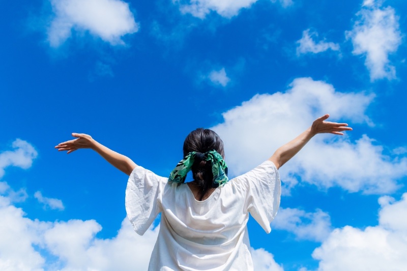 空に向かって手を広げる女性