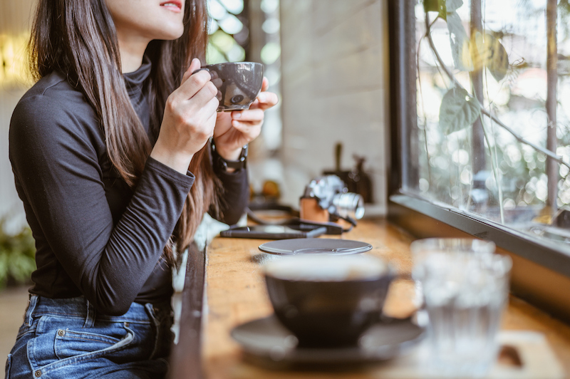 カフェで飲み物を飲む女性