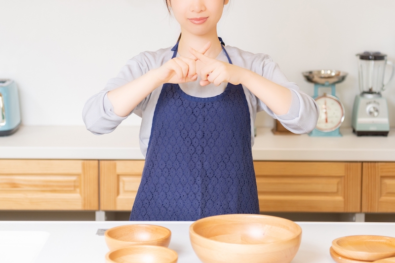 指でバツを作る女性