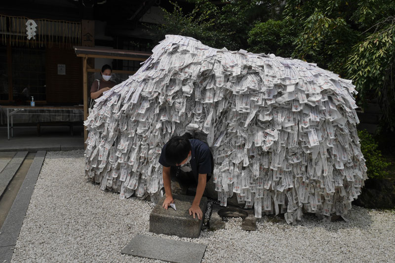 祈願の作法に従って、形代を持って穴をくぐり、最後は縁切り縁結び碑に貼り付けます