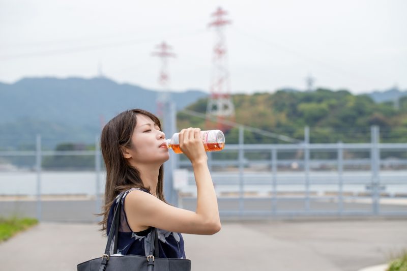 ペットボトルの麦茶を飲んでいる女性