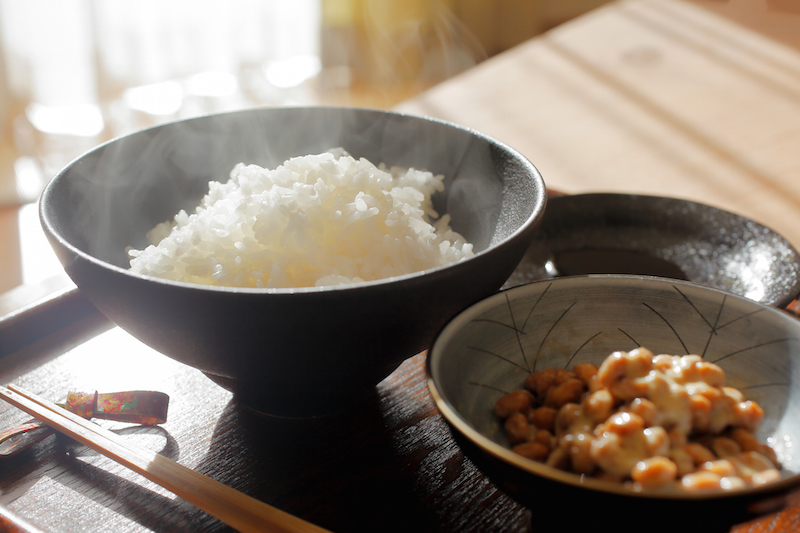 白いご飯、納豆、しょうゆ、箸の置かれたおぼん