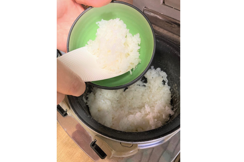 マーナの極しゃもじで炊飯器のご飯をお茶碗に装っている様子