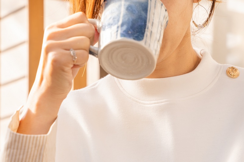 女性がマグカップで飲んでいる所