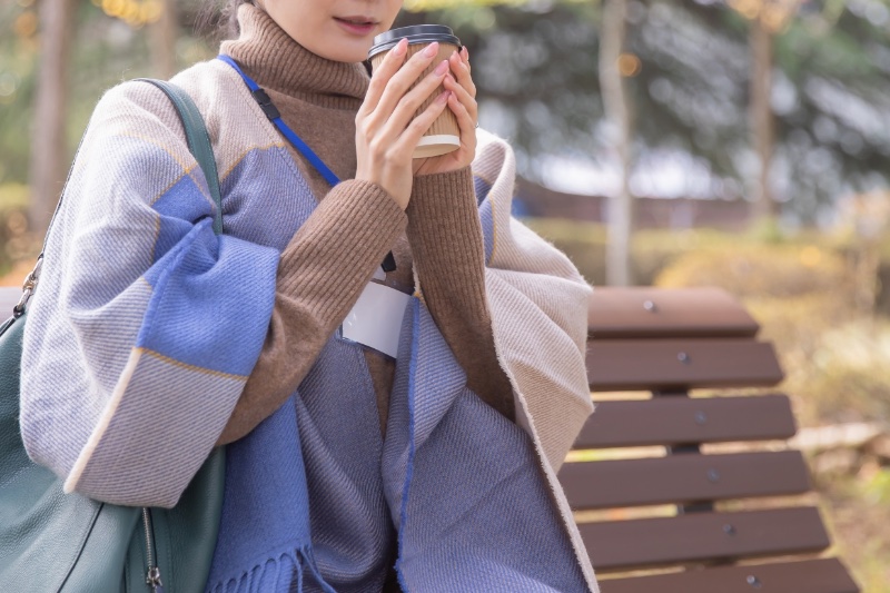 両手でホットドリンクを飲む人