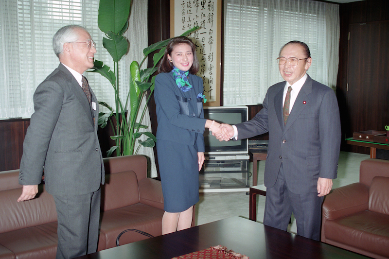 渡辺美智雄外相（当時）と握手をかわされる雅子さま。左は父親の小和田恆さん（1993年2月9日、Ph／JIJI PRESS）