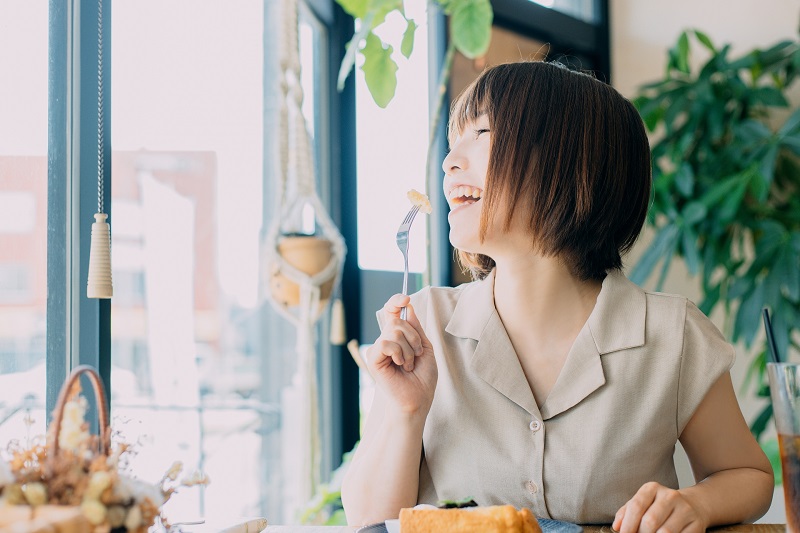 カフェでスイーツを食べている女性