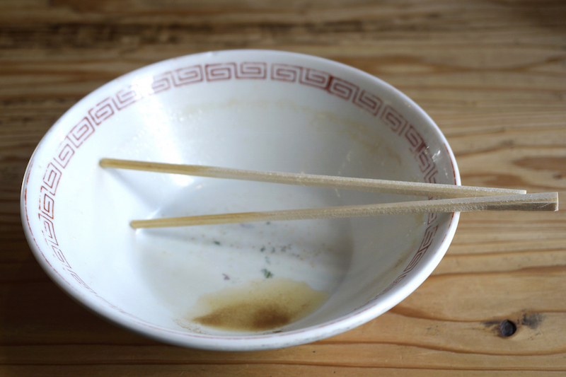 ラーメンどんぶりの食べたあと箸が乗っている