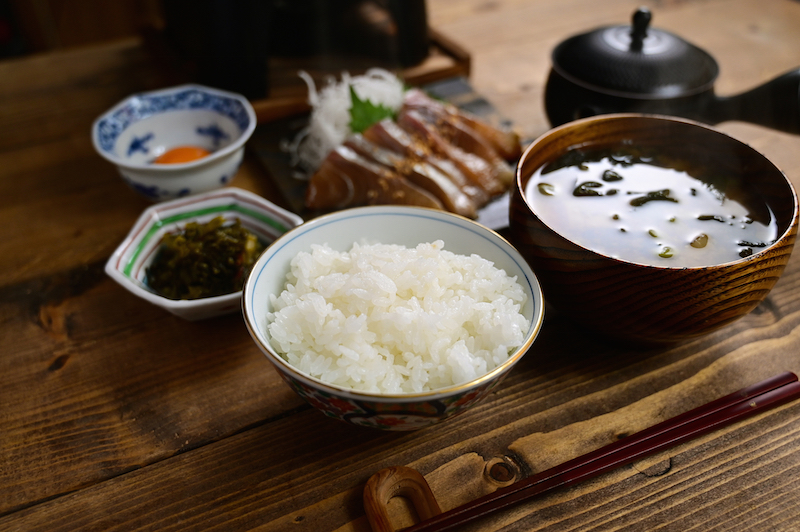 お刺身と汁物、小鉢、ご飯が並べられている