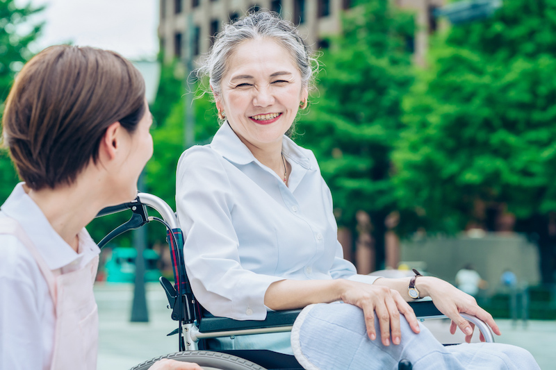 車椅子の女性に話しかける介護士