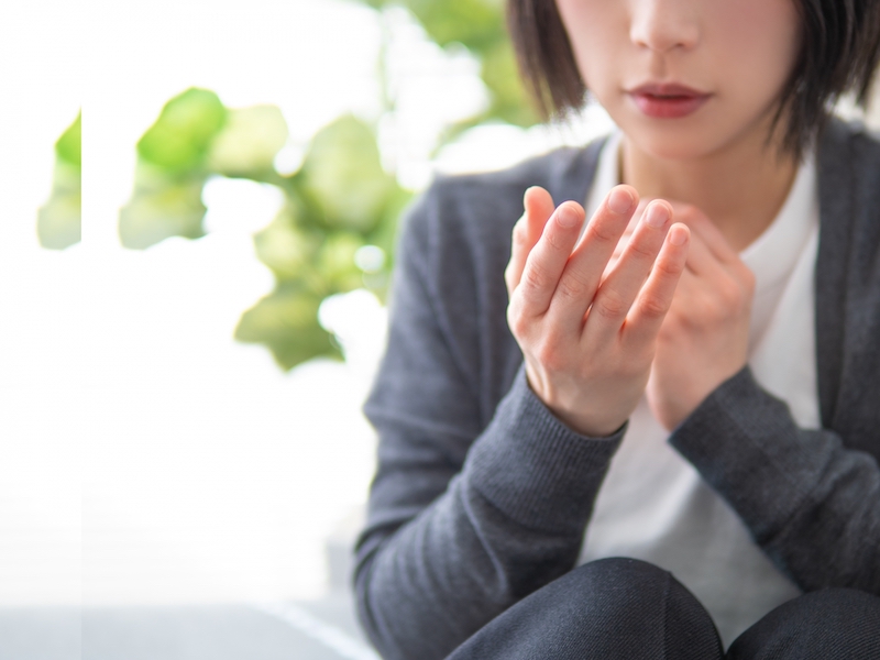 手を見つめる女性