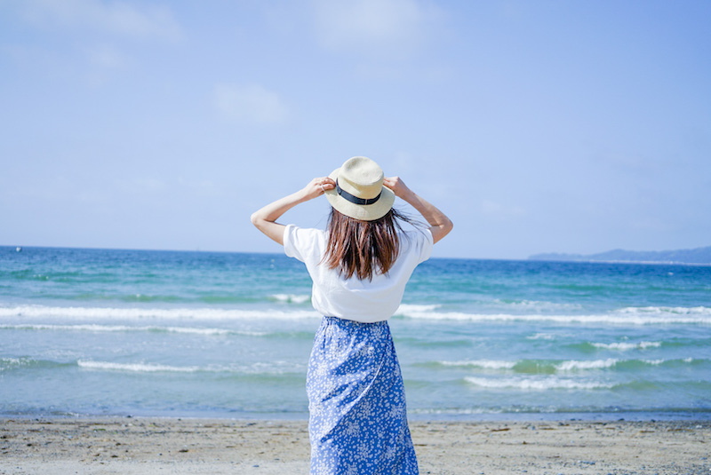 海に向かう、スカート姿の女性