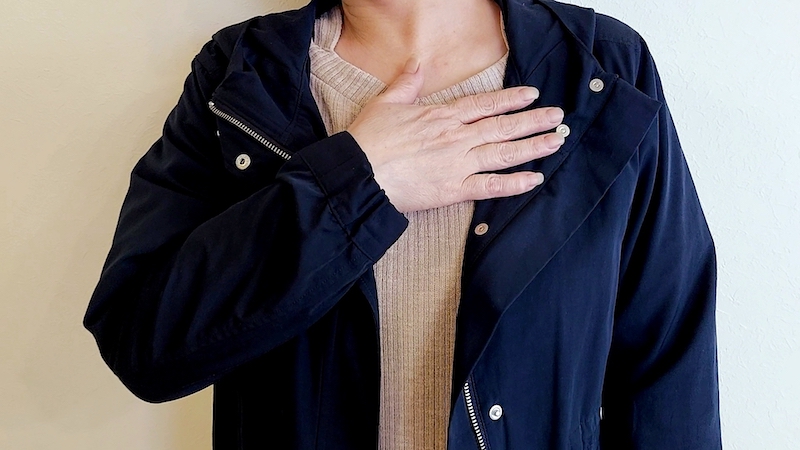 胸を押さえる女性