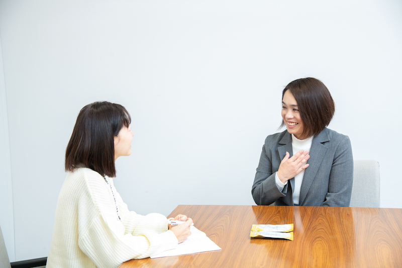 白い服の女性とジャケットを着た女性が話している