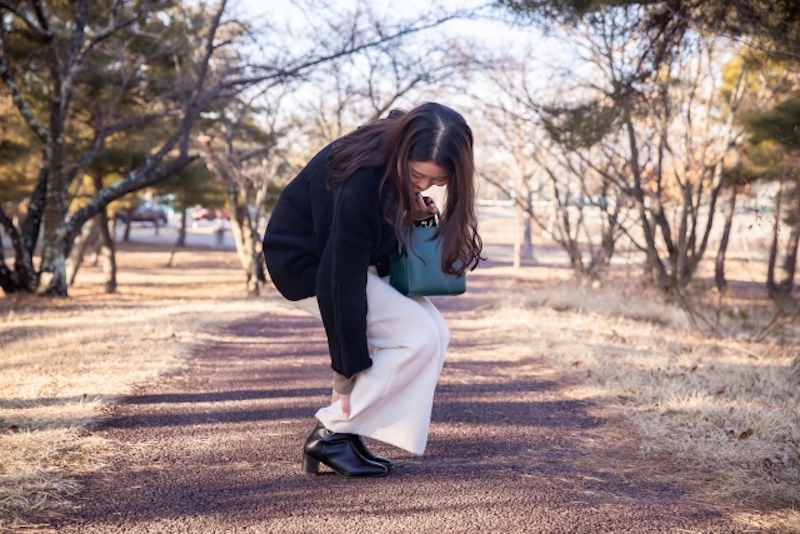 足元を押さえる女性