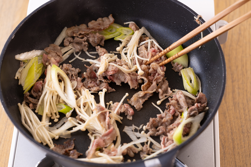 フライパンでサラダ油を中火で熱し、牛肉を炒める。白ねぎ、えのきをキッチンバサミで一口大に切りながら入れて炒める