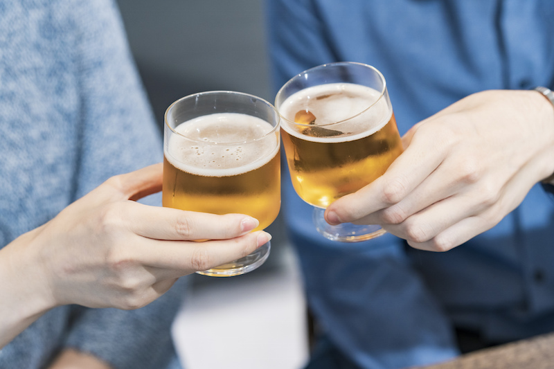 ビールが入ったグラスで乾杯する手元