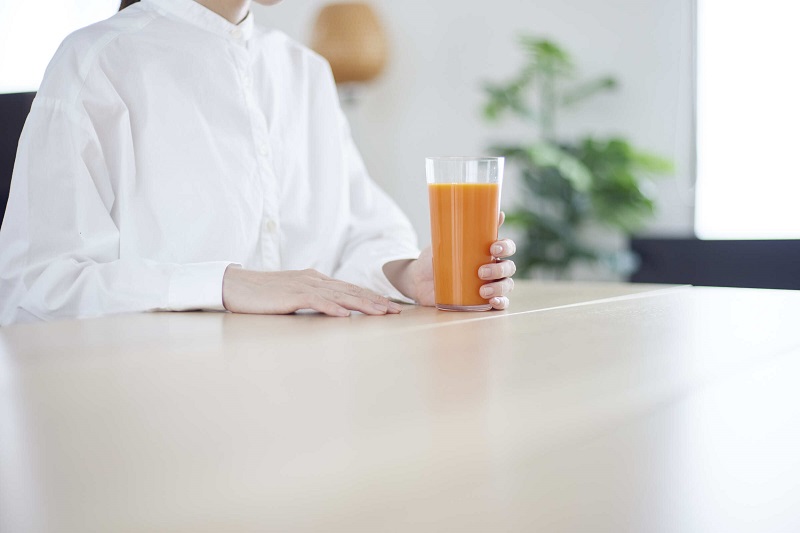 野菜ジュースを飲もうとしている女性