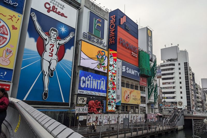 グリコの看板前には同じポーズで撮影をしようと平日も多くの外国人観光客でにぎわう