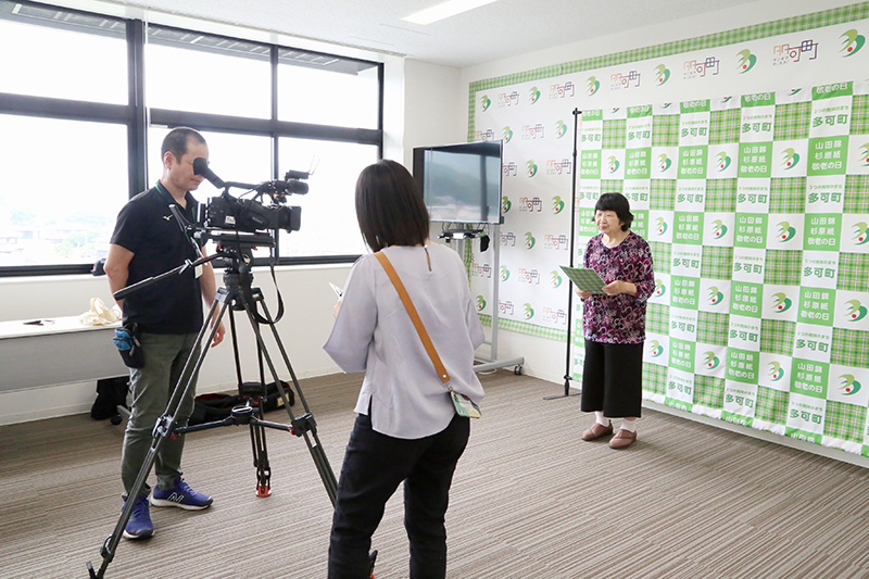 壁際に立ち、ゆっくりと原稿を読む（撮影／奥田珠貴）