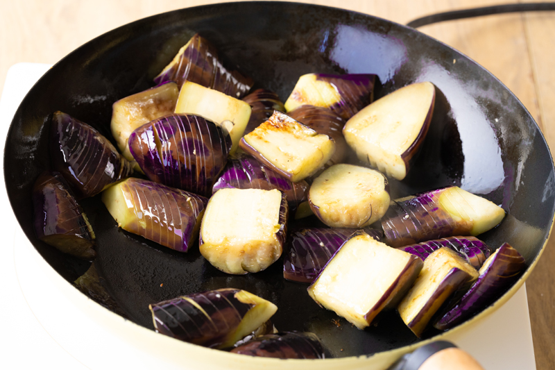 フライパンでサラダ油を中火で熱し、なすを加える。しんなりするまで約5分蒸し焼きにする。焼けたらキッチンペーパーで油を切る