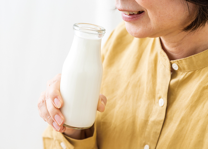 瓶にはいった牛乳を飲もうとしている女性の口元