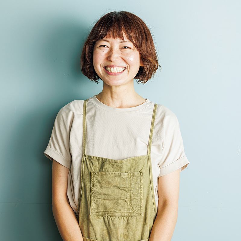 カーキのエプロンをつけた女性