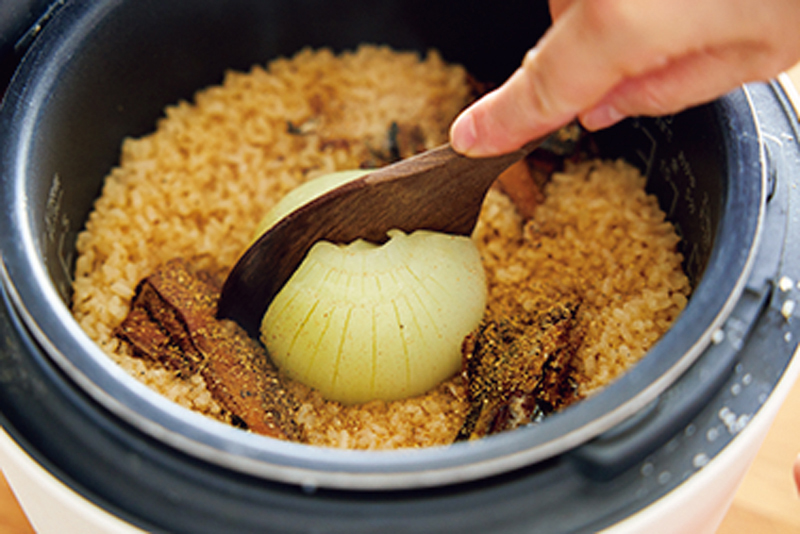 炊飯釜の中で玉ねぎをほぐしている