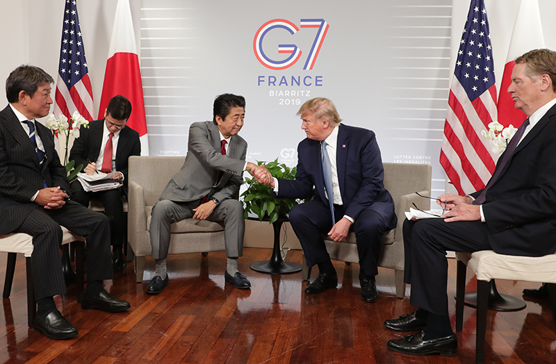 とうもろこしの追加輸入を求めたトランプ氏と握手を交わす安倍元首相（2019年。写真／時事通信フォト）