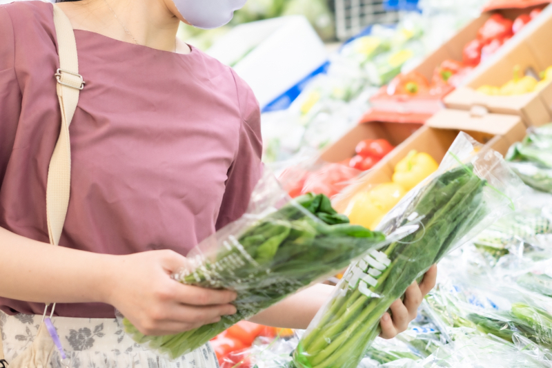 野菜を見比べる女性